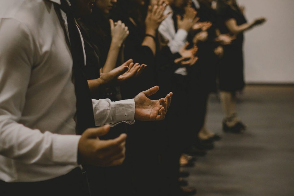 group of people praying - raising hands to pray