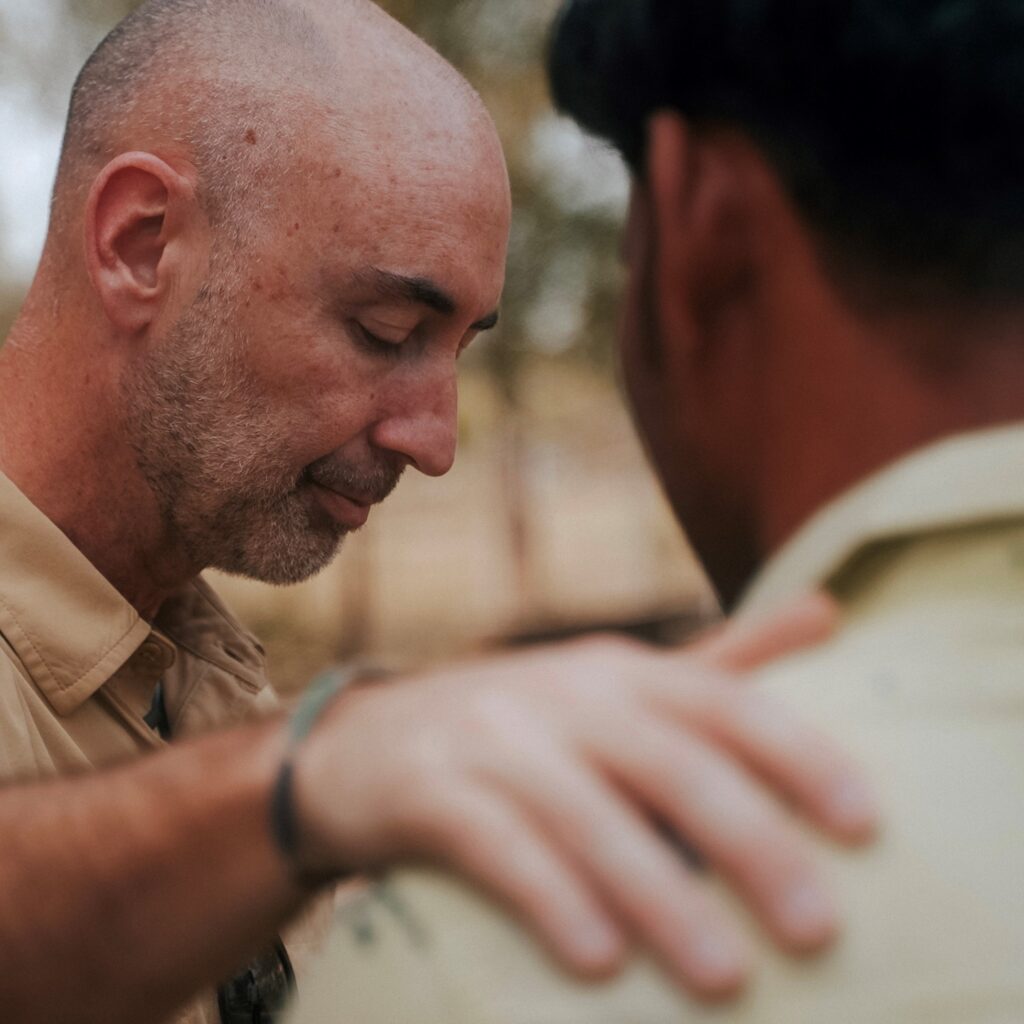 Man praying with persecuted Indian Christian