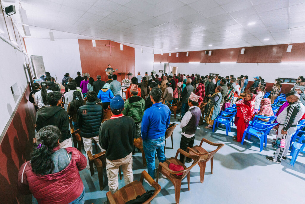 Persecuted Christians in Nepal stand during worship inside a church