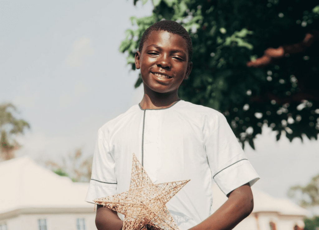 a persecuted Christian teen in Africa holds a Christmas ornament