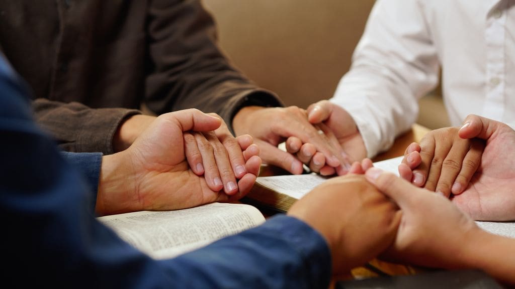 Um grupo de estudo da Bíblia de mãos dadas