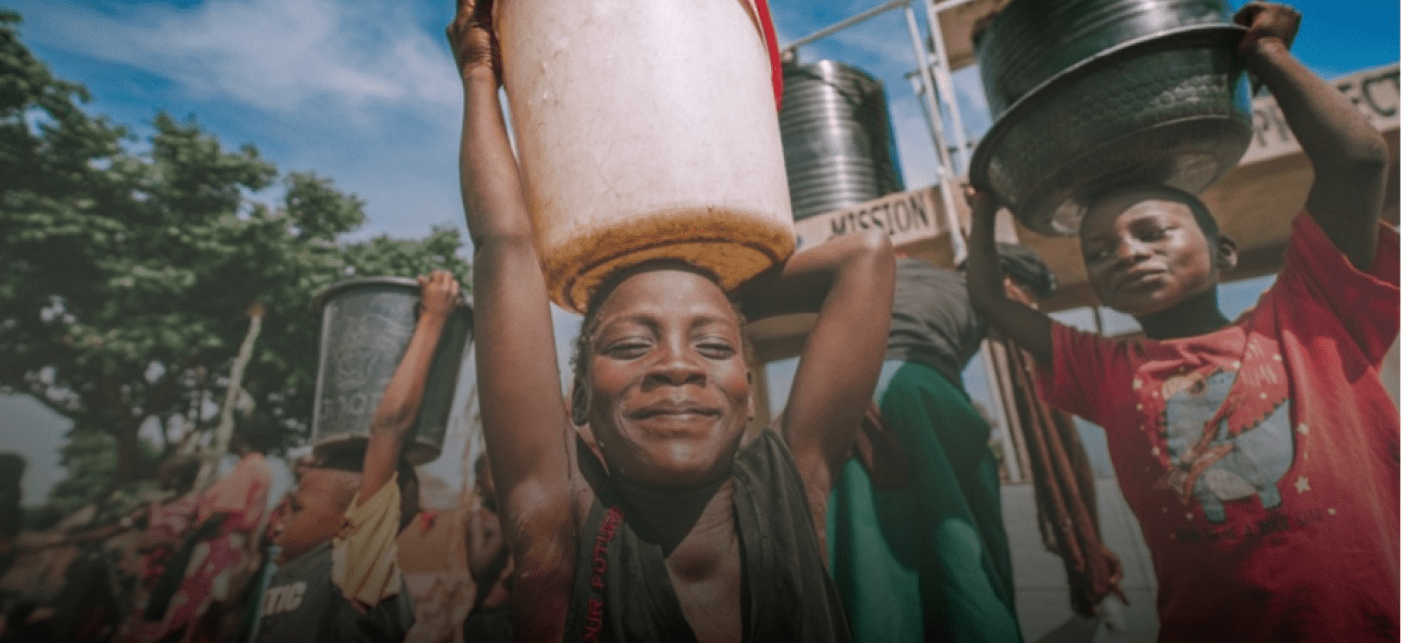 Children carrying safe drinking water from their new borehole