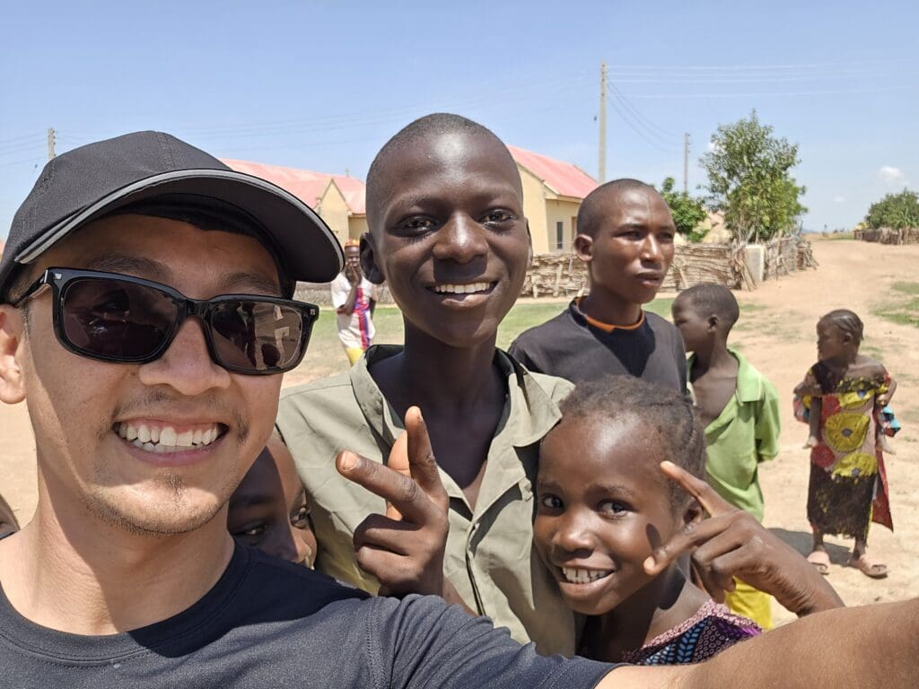 Jeud Mom with Nigerian children in an IDP camp, smiling together during a summer 2024 field visit