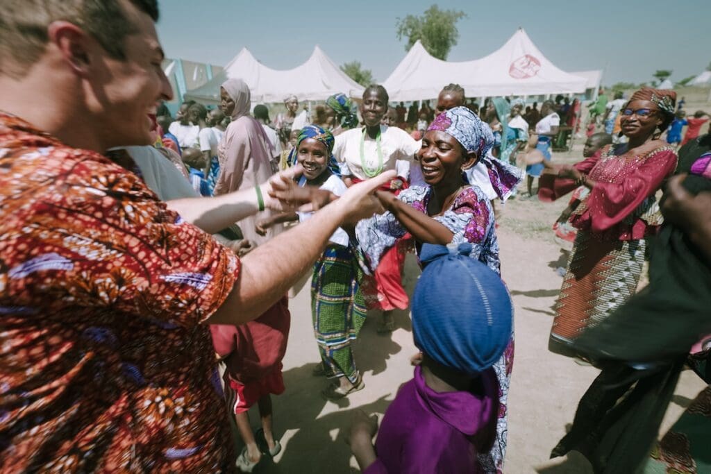 Ryan Miller dances with refugee Gladys at a "graduation" ceremony in a refugee camp
