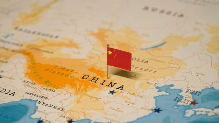 A map of China with a flag pinned to it.