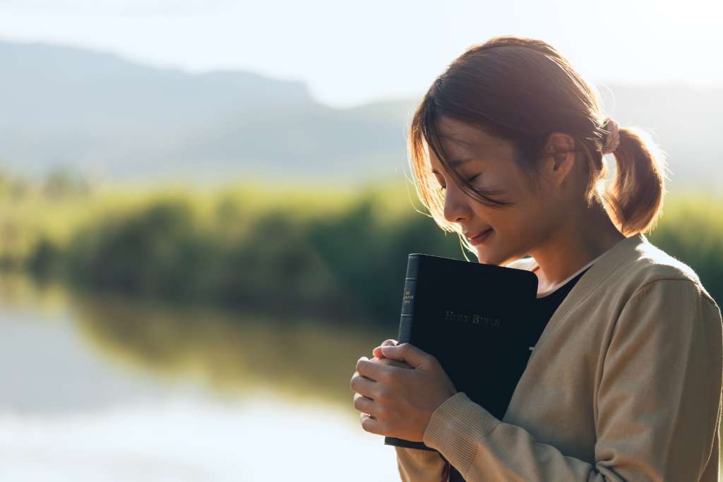 Christian woman praying over the bible