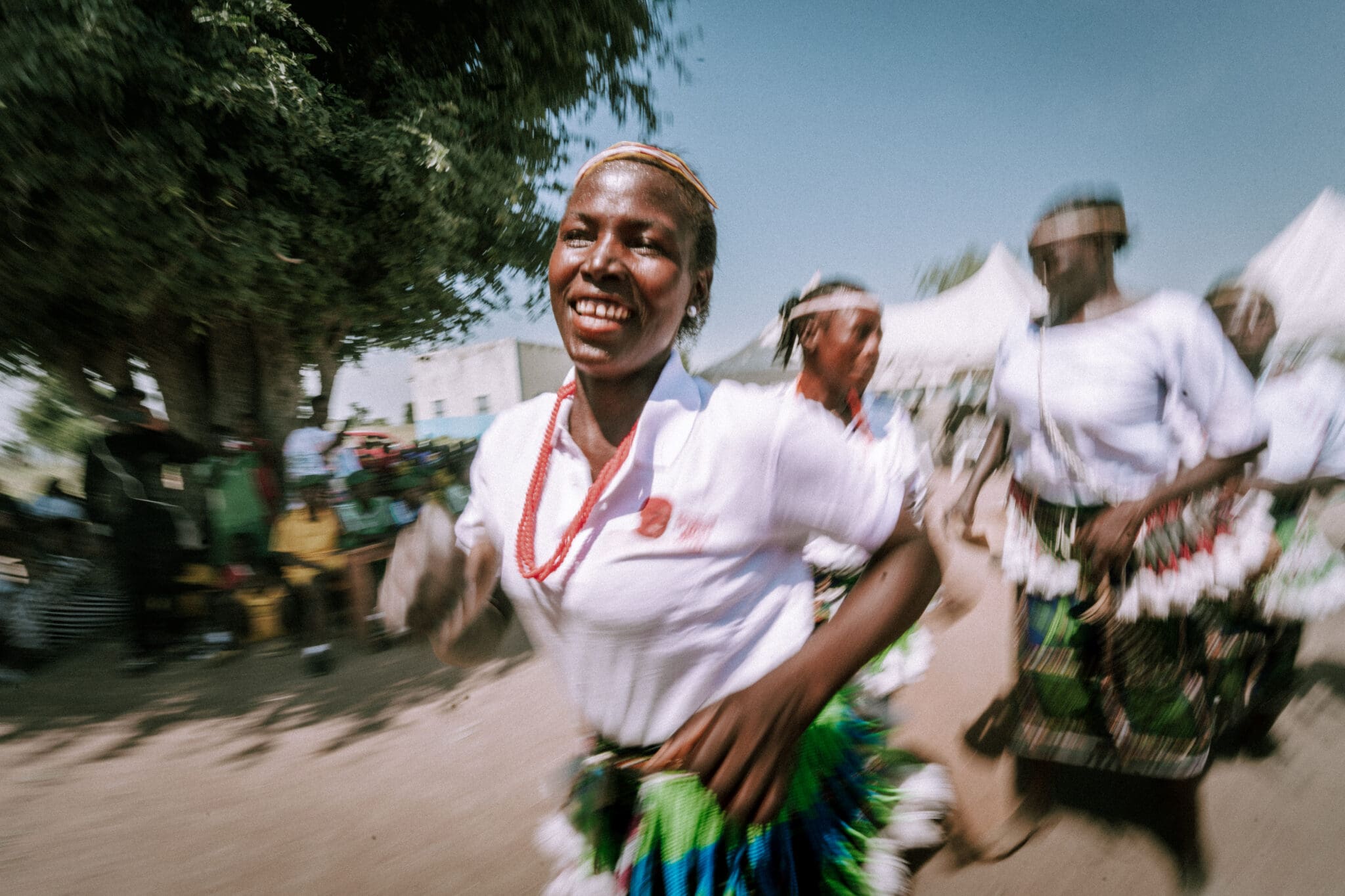 Women dance to celebrate the "graduation" of their IDP camp to self-sufficiency.